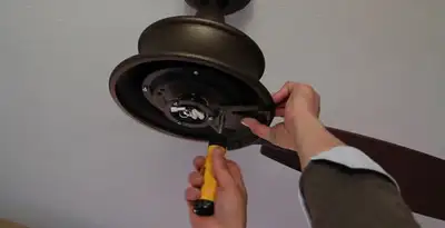 Electrician installing ceiling fan mounting bracket and fixture in Sacramento, CA
