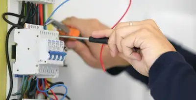 Electrician installing and adjusting circuit breakers in an electrical panel in Sacramento, CA