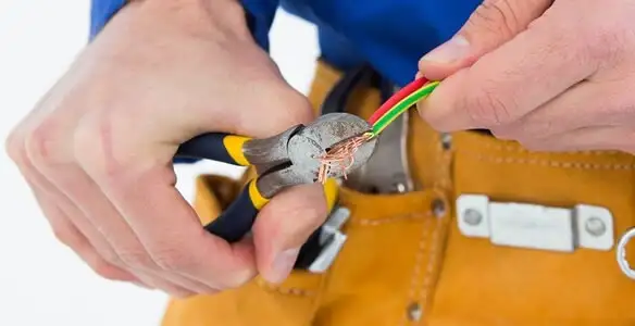 licensed electrician securing electrical wiring with professional tools during service work in Sacramento, CA