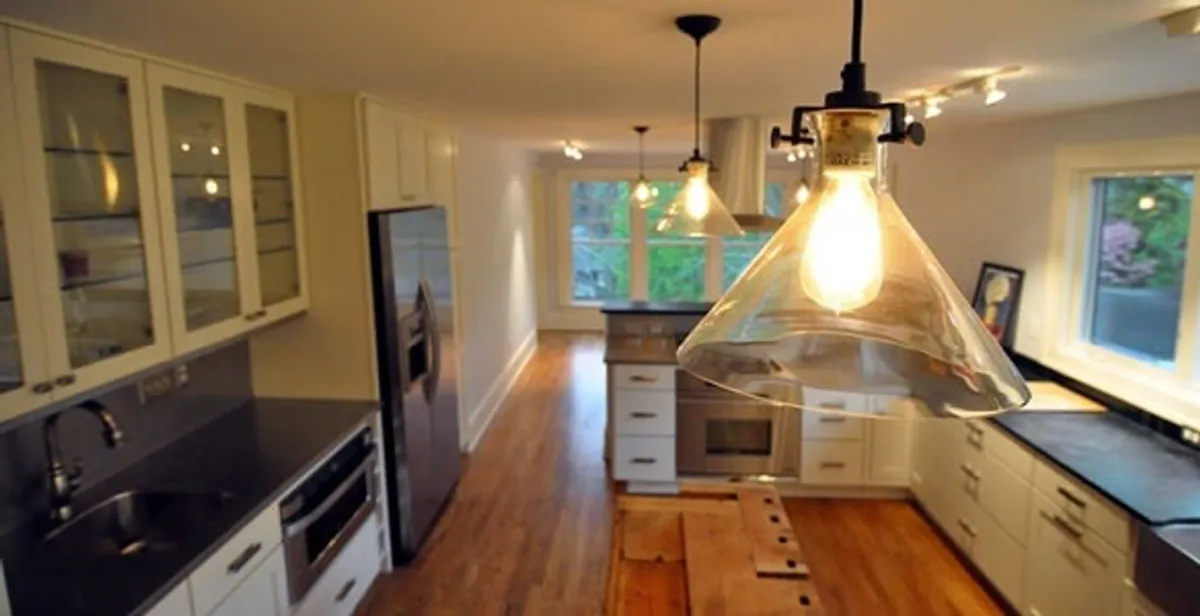Residential electrician installing modern indoor light fixture in a home in Sacramento, CA