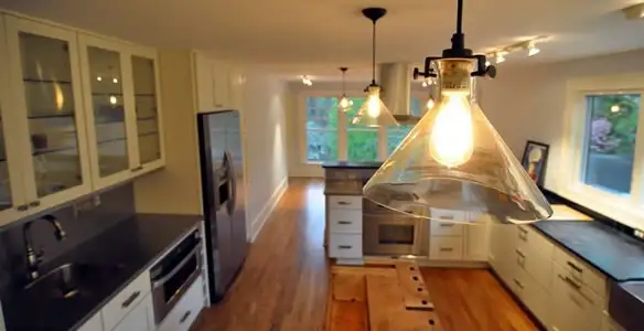 Residential electrician installing modern indoor light fixture in a home in Sacramento, CA